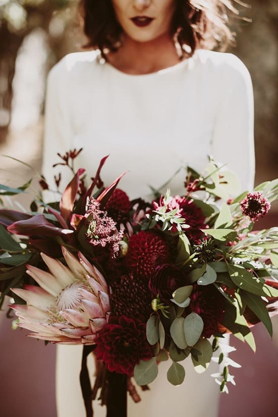 Bohemian burgundy Protea wedding bouquet | Lauren Scotti Photography via Junebug Weddings