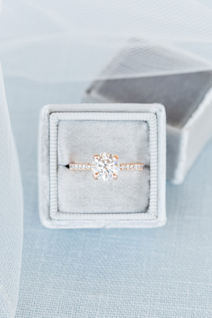 Rose gold solitaire diamond engagement ring with pave band displayed in grey velvet ring box | Photography: Cavin Elizabeth Photography