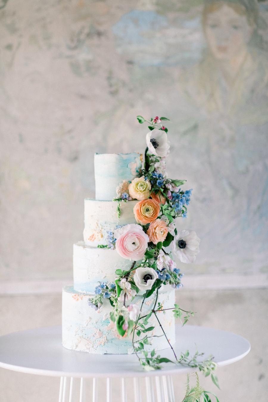 Spring Pastel Wedding Ideas | Romantic pastel buttercream wedding cake in pale blue and peach with cascading fresh flowers and greenery. | Photography: Kate Preftakes via Style Me Pretty