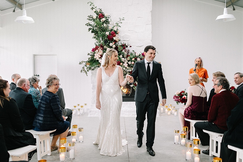 Bride and groom walking down the aisle after romantic barn wedding ceremony | Nattnee Photography