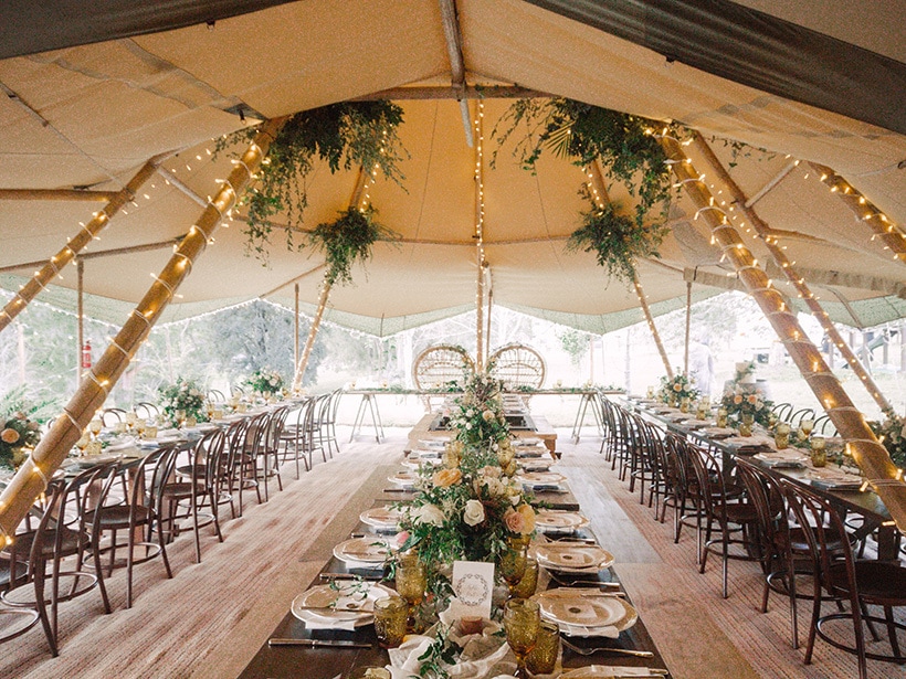 Amber and greenery boho tipi wedding reception with peacock chairs for the bride and groom | Byron Loves Fawn