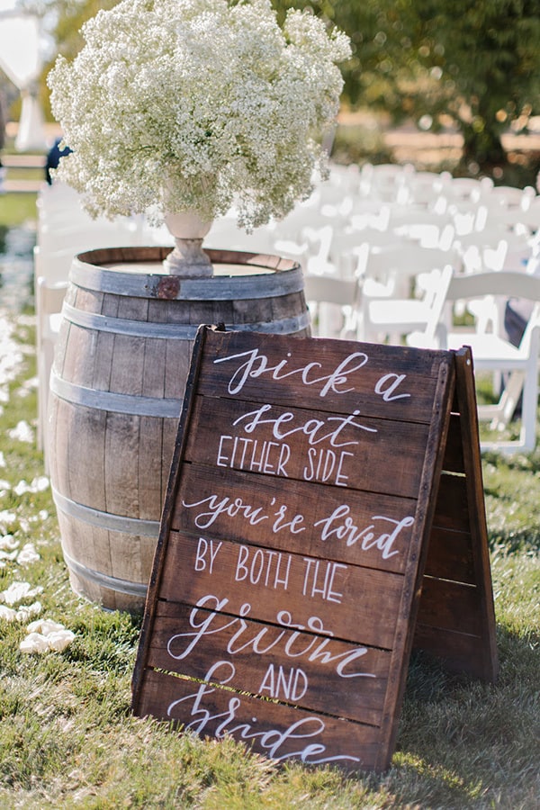 Wedding ceremony seating sign - "Pick a seat either side, you're loved by both the groom and bride." | Marissa Kay Photography via Borrowed & Blue